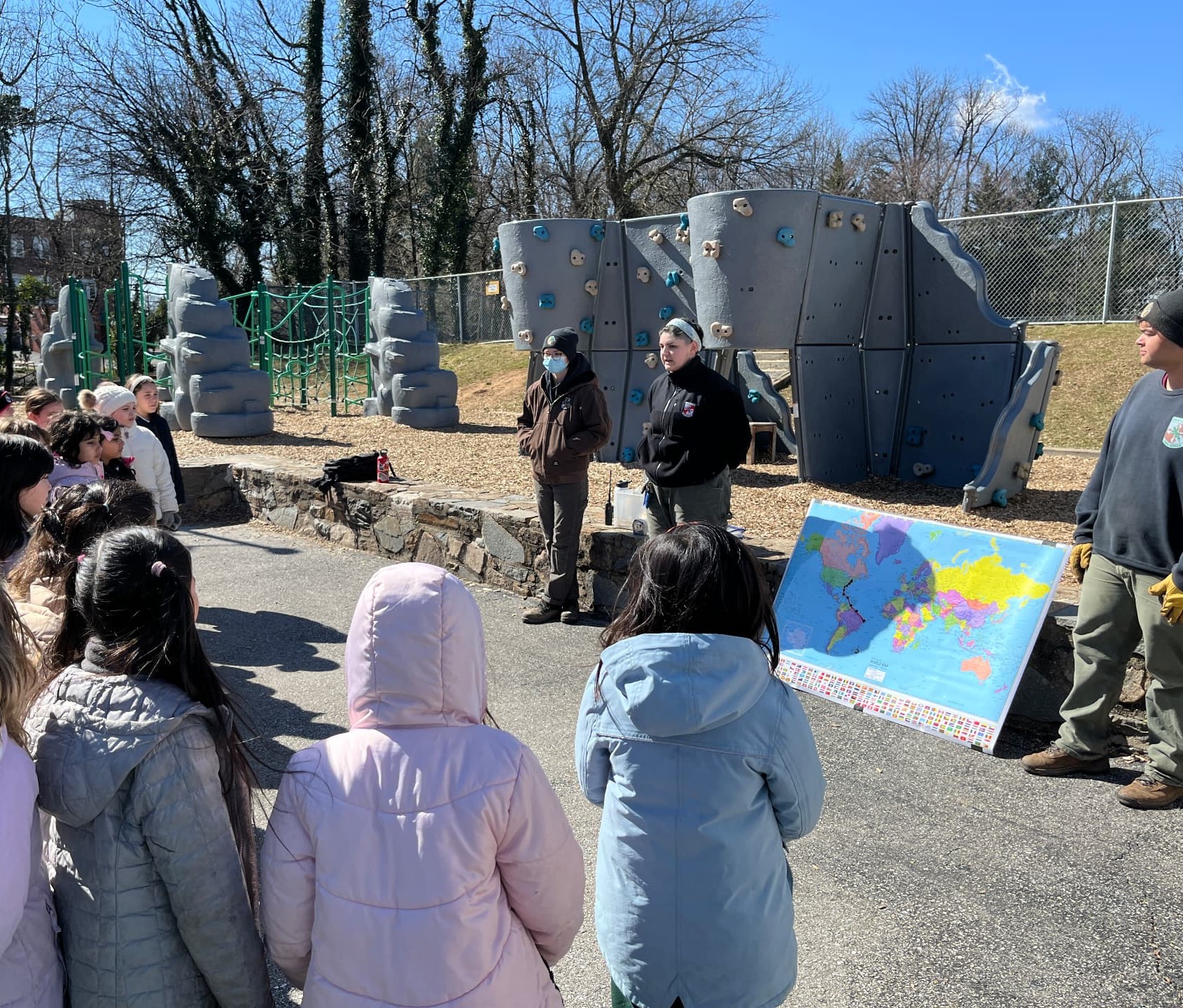 Conservation program presenters use a world map to show Bryn Mawr School students an osprey migration route