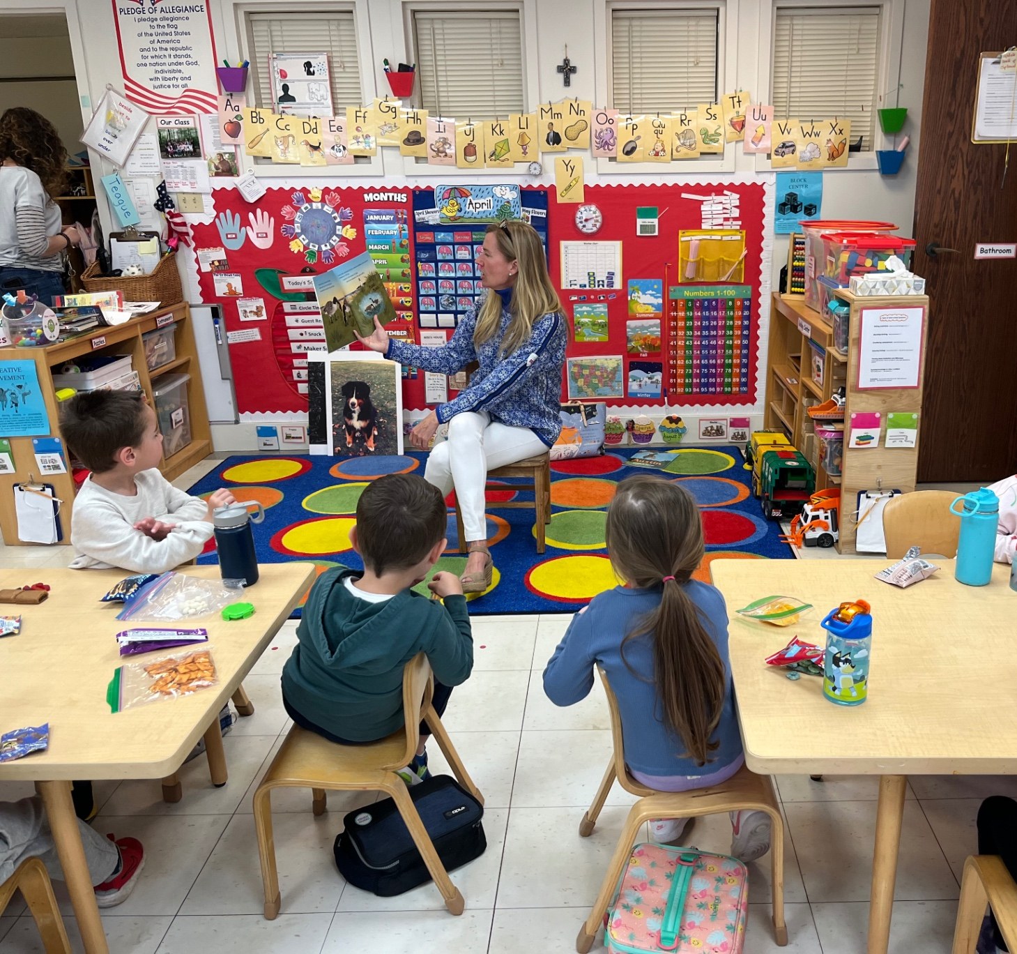 Letitia Burton reading the picture book Guthrie & Gretzky to preschool students gathered around a classroom table in Southport, Connecticut